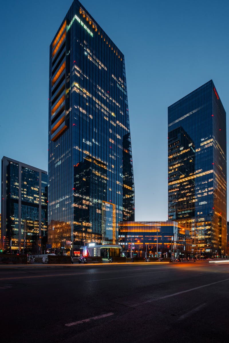 Illuminated skyscrapers stand tall against the twilight sky, showcasing urban architecture.